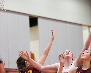 YSU's Mary Dunn, center, and Loyola's Kat Nolan, left, and Abby O'Connor watch as the ball flies overhead during the first half of their game at YSU on Friday night. EMILY MATTHEWS | THE VINDICATOR