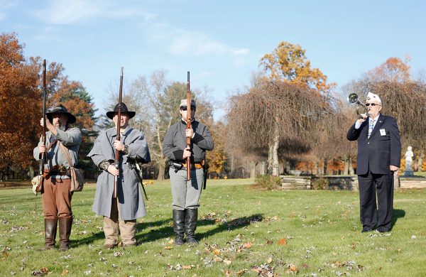 John P. "JP" Brown III, far right, of Boardman, plays taps while, from left, Kellie Wright, of Leetonia, Robert Lintz, of Niles, and Dallas Wright, of Leetonia, stand after saluting veterans during the Forgotten Heroes program in Forest Lawn Cemetery in Boardman on Sunday. EMILY MATTHEWS | THE VINDICATOR