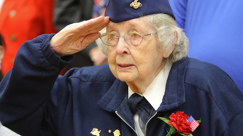 Veteran Donna Sheldon of Girard salutes as the Liberty High School choir sings the “Star Spangled Banner.” She attended the Veterans Day assembly Monday afternoon at Liberty High School.