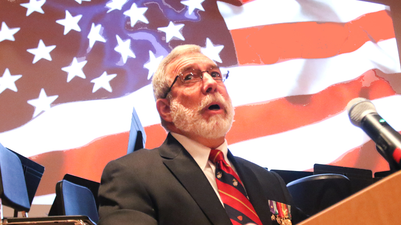 Roger Bacon, a Marine Corps veteran who served in the Vietnam War, addresses the Austintown Fitch High School auditorium filled with other veterans and students who paid them tribute during the school’s annual Veterans Day ceremony Monday.