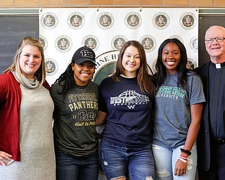 From left, Ursuline High School Assistant Principal Maggie Matune, senior basketball players Dayshanette Harris, Lindsay Bell, Anyah Curd, and President Father Richard Murphy pose for a photo during the signing day ceremony at Ursuline High School on Wednesday. EMILY MATTHEWS | THE VINDICATOR