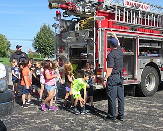 Neighbors | Jessica Harker.Members of the Boardman Fire Department walked first-graders at Stadium Drive Elementary School around the fire truck, showing them the different parts of the truck including the hose and ladders.