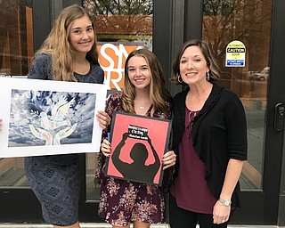 Neighbors | Submitted.Emily Olexa held her art work, “Peace in the Air,” which recieved honorable mention, and Jenna Hughes held her first place submission, “Anti Violence,” along with art teacher Jenna Hudock.