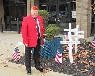 Neighbors | Jessica Harker.Paul Schultz posed next to a wooden cross with James Prommersberger's name. Prommersberger is the father of Austintown teacher Kristen O'Neil and was killed in combat while serving with Schultz.