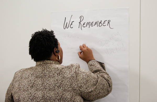 Victoria Allen, the president of the ICU Blockwatch, writes the names of people she knew who have died from violence at a community meeting at St. Dominic Church on Thursday night. EMILY MATTHEWS | THE VINDICATOR