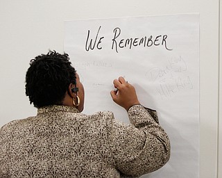Victoria Allen, the president of the ICU Blockwatch, writes the names of people she knew who have died from violence at a community meeting at St. Dominic Church on Thursday night. EMILY MATTHEWS | THE VINDICATOR