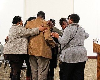 Community leaders and members hug relatives of Valarica Blair and her 3-month-old son Tariq Morris, who were killed in a triple homicide last week, during a community meeting at St. Dominic Church on Thursday night. EMILY MATTHEWS | THE VINDICATOR