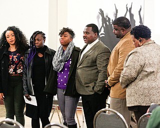 Three relatives, left, of Valarica Blair and her 3-month-old son Tariq Morris, who were killed in a triple homicide last week, stand in the front of the room with community leaders during a community meeting at St. Dominic Church on Thursday night. EMILY MATTHEWS | THE VINDICATOR