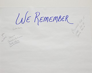 Names of people who have died from violence are written on posters at a community meeting at St. Dominic Church on Thursday night. EMILY MATTHEWS | THE VINDICATOR