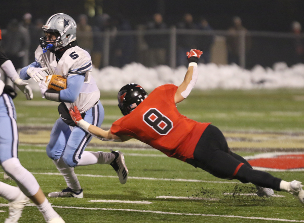             ROBERT  K. YOSAY | THE VINDICATOR..Canfield Cardinals lose in a Division III Region 9  final at Warren's Mollenkopf stadium ...Kenston's Jack Porter #5.. gets stopped behind the line by Canfields #8 Colin Hritz  during first half action