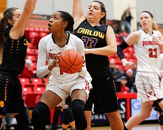 YSU's Amara Chikwe looks towards the hoop while Carlow's Emma Stille, left, and Bria Rathway, right, try to block her during their game Friday night at YSU. EMILY MATTHEWS | THE VINDICATOR