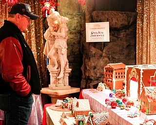 Tom Masiarik, of Chippewa, looks at gingerbread houses displayed in the Memories of Christmas Past exhibition at The Arms Family Museum on Saturday. EMILY MATTHEWS | THE VINDICATOR