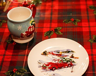 Christmas themed plates and mugs sit on a table in the Memories of Christmas Past exhibition at The Arms Family Museum on Saturday. EMILY MATTHEWS | THE VINDICATOR