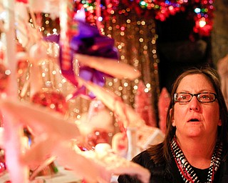 Barbara Robeson, of Youngstown, looks at decorations on display in the Memories of Christmas Past exhibition at The Arms Family Museum on Saturday. EMILY MATTHEWS | THE VINDICATOR