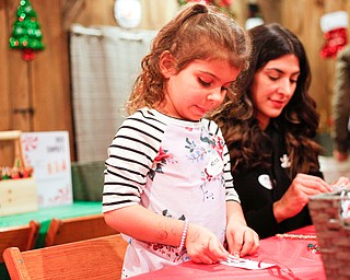 Aria Ries, 5, of Niles, makes Christmas ornaments with her mom Gina Ries at the Memories of Christmas Past exhibition at The Arms Family Museum on Saturday. EMILY MATTHEWS | THE VINDICATOR