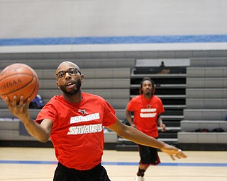 Local theater actor James Major Burns grabs the ball that local rapper J.Howell, back, threw while warming up for the Rising Stars basketball game at East High School on Sunday. EMILY MATTHEWS | THE VINDICATOR