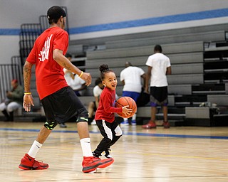 RJ Johnson, 4, of Liberty, plays with local artist Ron Johnny while he warms up for the Rising Stars basketball game at East High School on Sunday. EMILY MATTHEWS | THE VINDICATOR