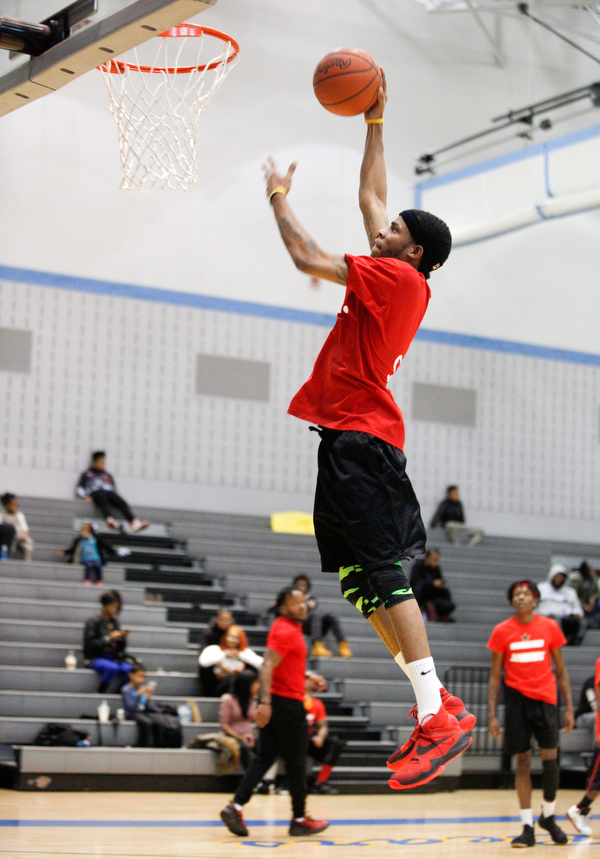 Local artist Ron Johnny jumps for a basket while warming up for the Rising Stars basketball game at East High School on Sunday. EMILY MATTHEWS | THE VINDICATOR