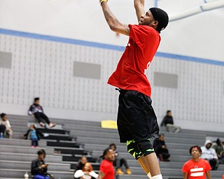 Local artist Ron Johnny jumps for a basket while warming up for the Rising Stars basketball game at East High School on Sunday. EMILY MATTHEWS | THE VINDICATOR