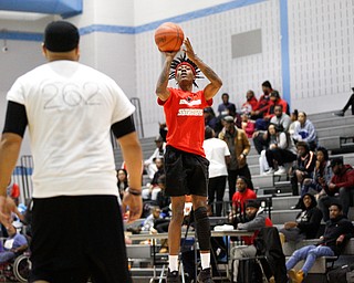 Local artist JonezyTooCool shoots the ball over local artist Lester Scott during the Rising Stars basketball game at East High School on Sunday. EMILY MATTHEWS | THE VINDICATOR