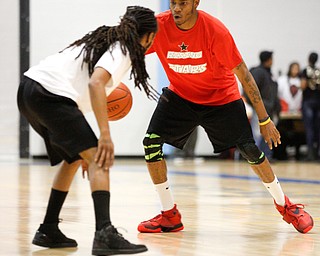 Local artist Ron Johnny tries to get the ball past other local artist Lamar Makle during the Rising Stars basketball game at East High School on Sunday. EMILY MATTHEWS | THE VINDICATOR