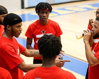 Local artist Ron Johnny, left, talks to his teammates during the Rising Stars basketball game at East High School on Sunday. EMILY MATTHEWS | THE VINDICATOR