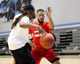 Local barber Daniel Lopez, right, tries to hit the ball away from local promoter Keylin Griffin during the Rising Stars basketball game at East High School on Sunday. EMILY MATTHEWS | THE VINDICATOR