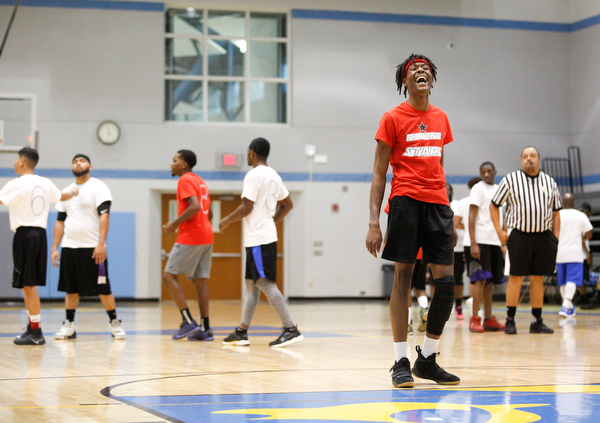 Local artist JonezyTooCool laughs before shooting a foul shot during the Rising Stars basketball game at East High School on Sunday. EMILY MATTHEWS | THE VINDICATOR