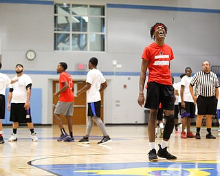 Local artist JonezyTooCool laughs before shooting a foul shot during the Rising Stars basketball game at East High School on Sunday. EMILY MATTHEWS | THE VINDICATOR