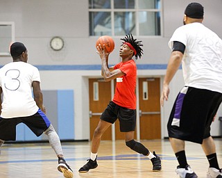 Local artist JonezyTooCool looks to pass the ball during the Rising Stars basketball game at East High School on Sunday. EMILY MATTHEWS | THE VINDICATOR