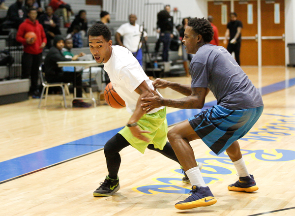 Campbell alumnus Terrance Phillips, left, tries to keep the ball away from Youngstown alumnus Charles Thomas during the Youngstown vs. Campbell alumni basketball game at East High School on Sunday. EMILY MATTHEWS | THE VINDICATOR