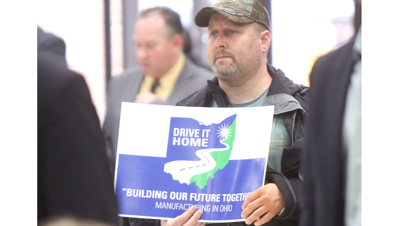Justin Brown, an 11-year General Motors Lordstown employee, holds up a sign during the kickoff of the Drive It Home campaign Monday at the United Auto Workers Local 1112 hall in Warren.
