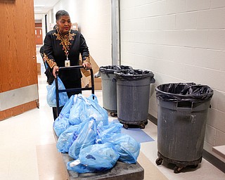 Angela McCoy, the Parent Engagement Coordinator at Williamson Elementary, pushes turkeys on a dolly to hand out at East High School on Monday night. EMILY MATTHEWS | THE VINDICATOR