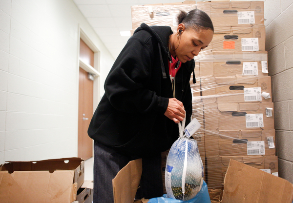 Tamekia Merriwether, an involved parent of a student at East High, bags turkeys to hand out at East High School on Monday night. EMILY MATTHEWS | THE VINDICATOR