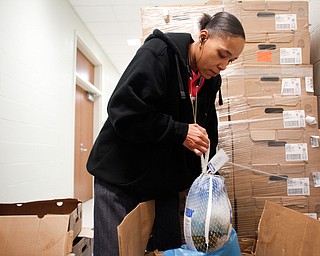 Tamekia Merriwether, an involved parent of a student at East High, bags turkeys to hand out at East High School on Monday night. EMILY MATTHEWS | THE VINDICATOR