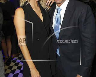 In this September 2018 photo, attorney Michael Avenatti, right, poses with Mareli Miniutti for a photo at a party in New York. Miniutti alleges that Avenatti dragged her across the floor of his Los Angeles apartment after an argument over money, according to court documents obtained Tuesday by The Associated Press. Avenatti, who was arrested the week before on a felony domestic violence charge, called the allegations "completely false." He's scheduled to appear in court next month. 