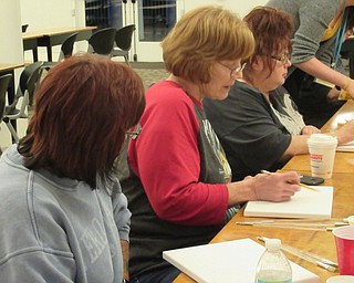Neighbors | Jessica Harker.Community member Ginger Kink sketched the outline of a pumpkin onto her canvas at the Art with Andrea event at the Austintown library.