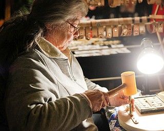 Kathy Bowman, of Austintown, personalizes and sells leather bracelets at Lanterman's Mill Olde Fashioned Christmas on Saturday. EMILY MATTHEWS | THE VINDICATOR