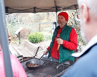 Ray Novotny, of Cornersburg, roasts chestnuts at Lanterman's Mill Olde Fashioned Christmas on Saturday. EMILY MATTHEWS | THE VINDICATOR