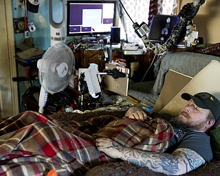 In this Friday, Nov. 16, 2018 photo, Jim Taft watches The History Channel from the confines of his bed at his home in West Columbia, S.C. Taft has experienced debilitating health issues after a neurosurgeon implanted Boston Scientific's Precision spinal cord stimulator in his back in 2014. 