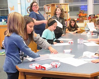 Neighbors | Jessica Harker.Student volunteer members of the Boo Squad filled safety buckets with rosters, first aid kits and other emergency supplies for class rooms at Poland Union Elementary School on Nov. 12.