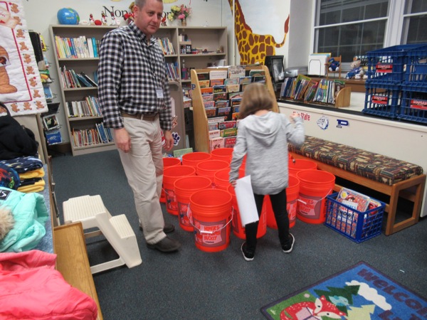 Neighbors | Jessica Harker.Principal Mike Masucci helped organize student members of the Boo Squad while they filled safety buckets for class rooms at Poland Union Elementary.