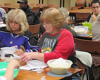 Neighbors | Jessica Harker.Community member Ginger Zink prepared to mix dough for the No Need to Knead event hosted by the Poland library on Nov. 19.