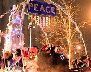 Kids from the Montessori School of the Mahoning Valley wave and throw out candy from the school's float in Youngstown's annual Holiday Parade on Friday night. EMILY MATTHEWS | THE VINDICATOR