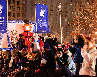 People sitting on Eastern Gateway Community College's float smile and wave to the crowd during Youngstown's annual Holiday Parade on Friday night. EMILY MATTHEWS | THE VINDICATOR