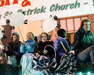 People ride on the back of the St. Patrick Parish float in Youngstown's annual Holiday Parade on Friday night. EMILY MATTHEWS | THE VINDICATOR