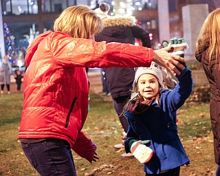 Cassi Samios, 7, of Brookfield, dances with family friend Karen Chaszeyka, of New Springfield, after the holiday parade and tree-lighting ceremony Friday night. EMILY MATTHEWS | THE VINDICATOR