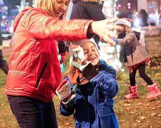 Cassi Samios, 7, of Brookfield, dances with family friend Karen Chaszeyka, of New Springfield, after the holiday parade and tree-lighting ceremony Friday night. EMILY MATTHEWS | THE VINDICATOR