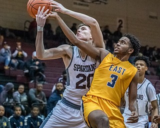 DIANNA OATRIDGE | THE VINDICATOR  Boardman's Shay Eicher (20) and Youngstown East's Deland Richardson (3) reach for a rebound during their game at Boardman High School Friday night.