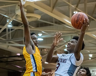 DIANNA OATRIDGE | THE VINDICATOR  Boardman's Derrick Anderson (3) drives to the hoop against the defense of Youngstown East's Deland Richardson (3) during their game at Boardman High School Friday night.